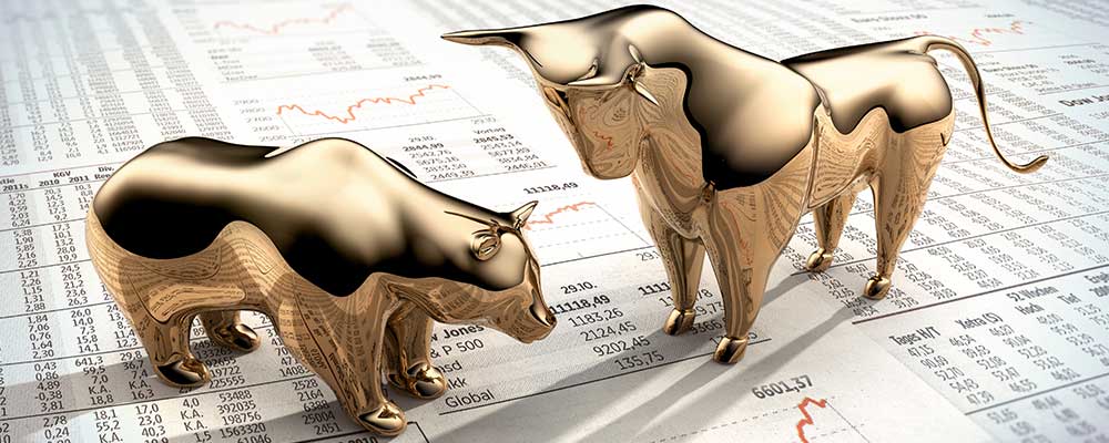 Brass Bear and Bull standing on newspaper revealing S&P 500 data.